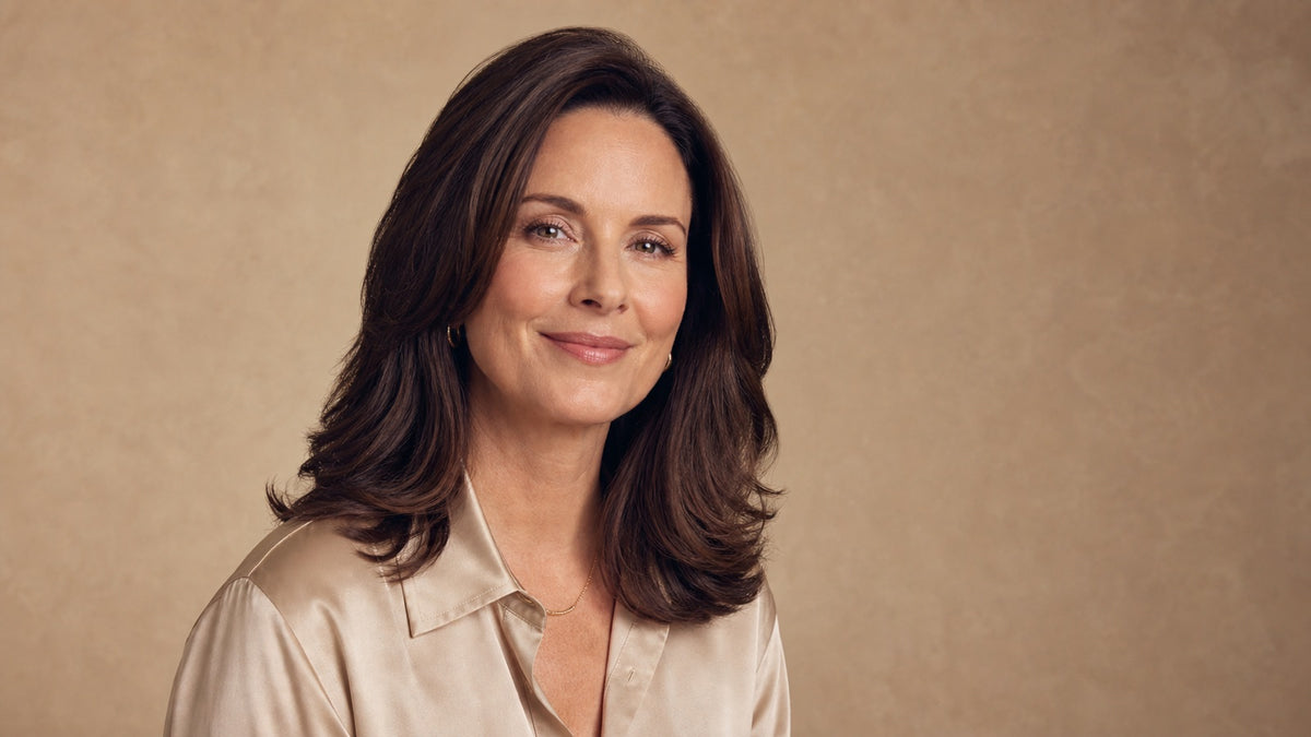 Confident woman in her 40s with full, healthy, glossy shoulder-length hair, calm and empowered editorial portrait