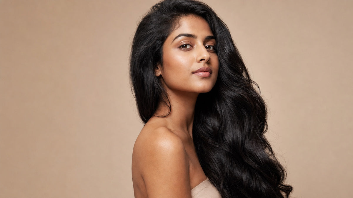 South Asian woman with long, thick, glossy black natural hair in soft editorial studio lighting