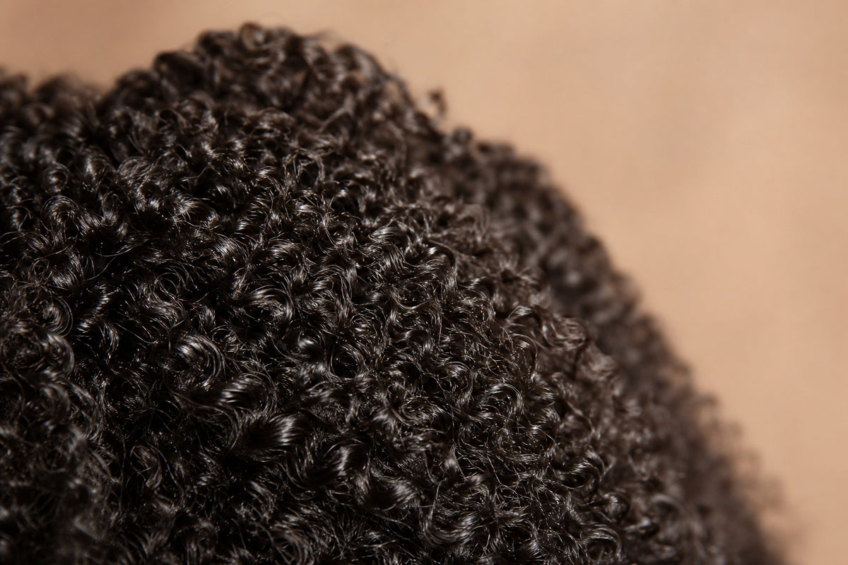 Close-up of defined, glossy curly and kinky human-hair extensions.