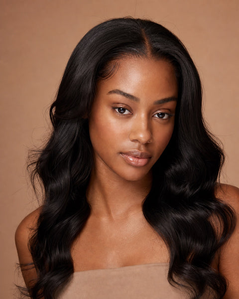Model showing the achievable look: natural-black body-wave hair with a flawless, natural part and hairline
