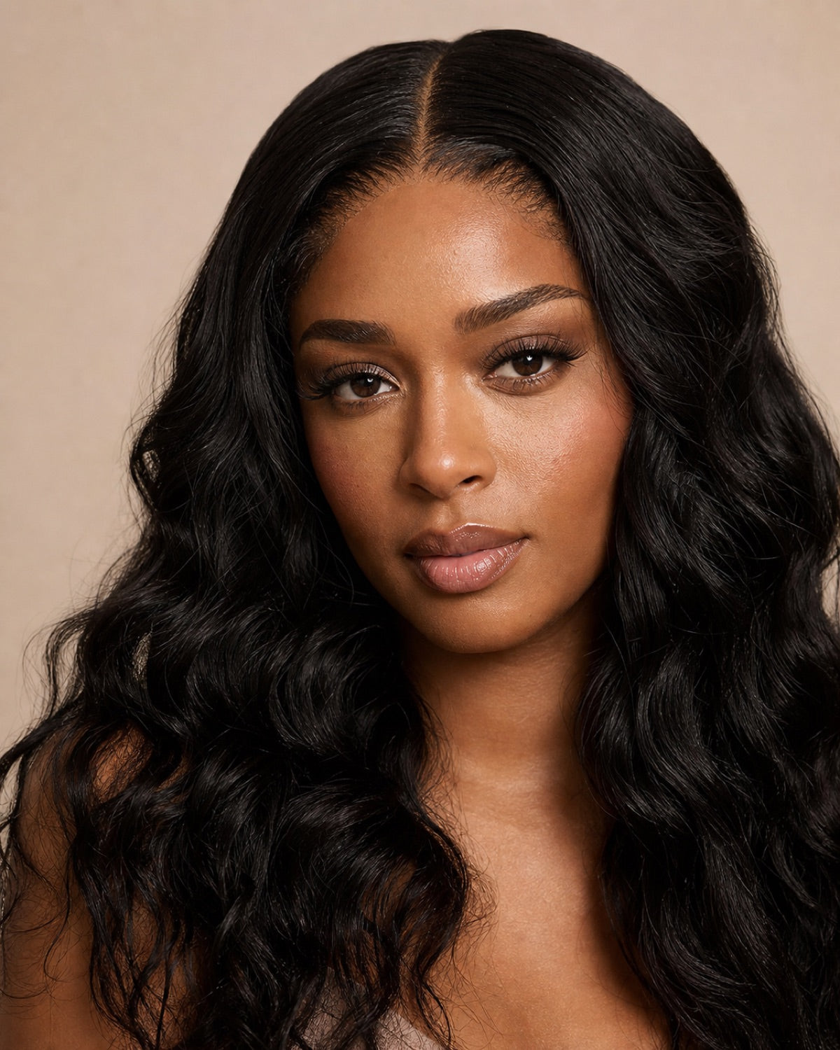 Model showing the achievable look: natural-black loose-wave hair with a seamless middle part