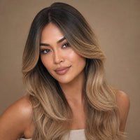 Model showing the achievable ombre look: black roots blending to honey-blonde #27 ends with a seamless natural part